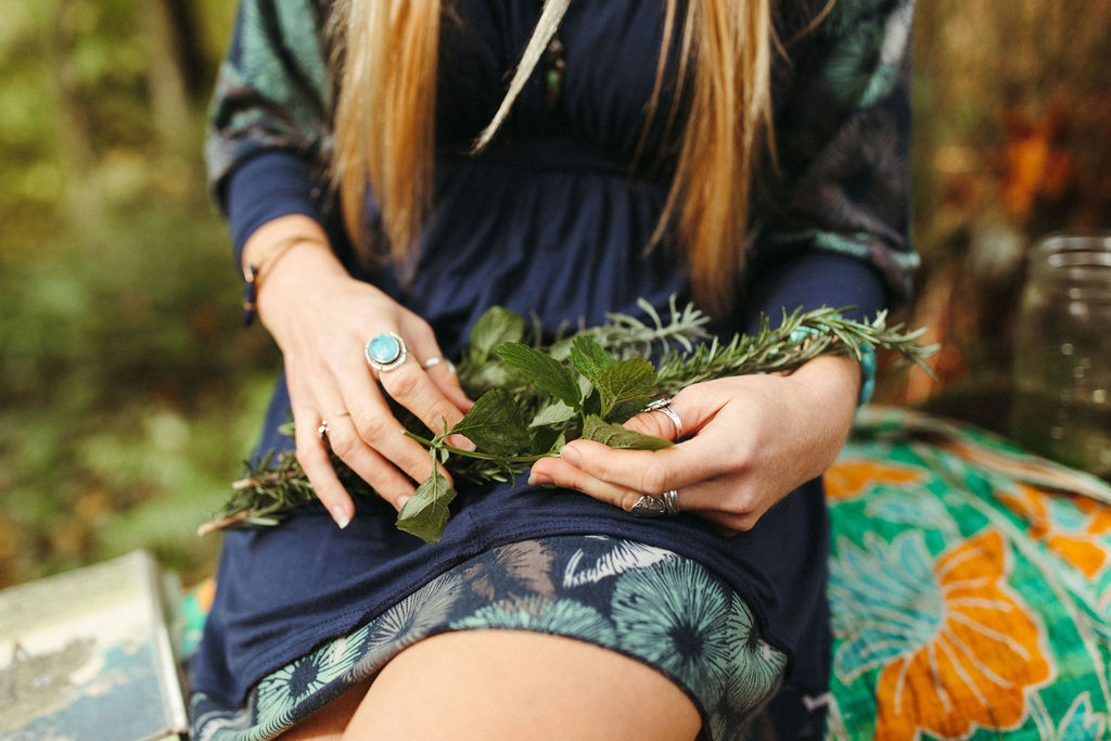 Lindsey Walker, Mockingbird Remedies, Holistic Clinical Herbalist and Integrative Wellness & Life Coach, woman sitting outside, holding herbs