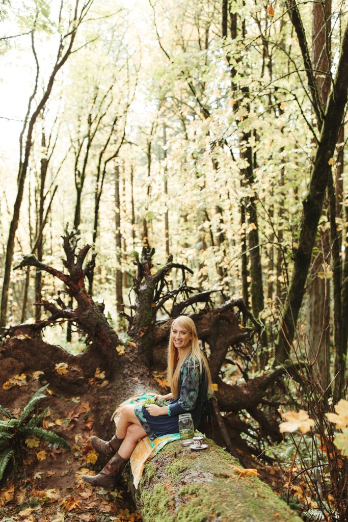 Meet Lindsey Walker, founder of Mockingbird Remedies sitting on a log. Lindsey is a Holistic Clinical Herbalist and Integrative Wellness & Life Coach